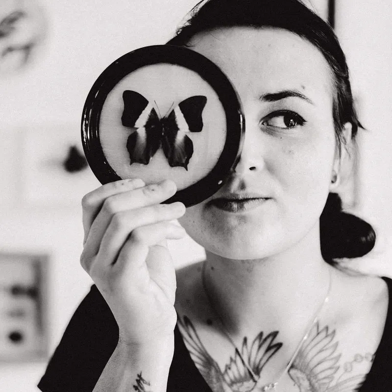 Portrait de Lisa Murville tenant une de ses œuvres devant son visage